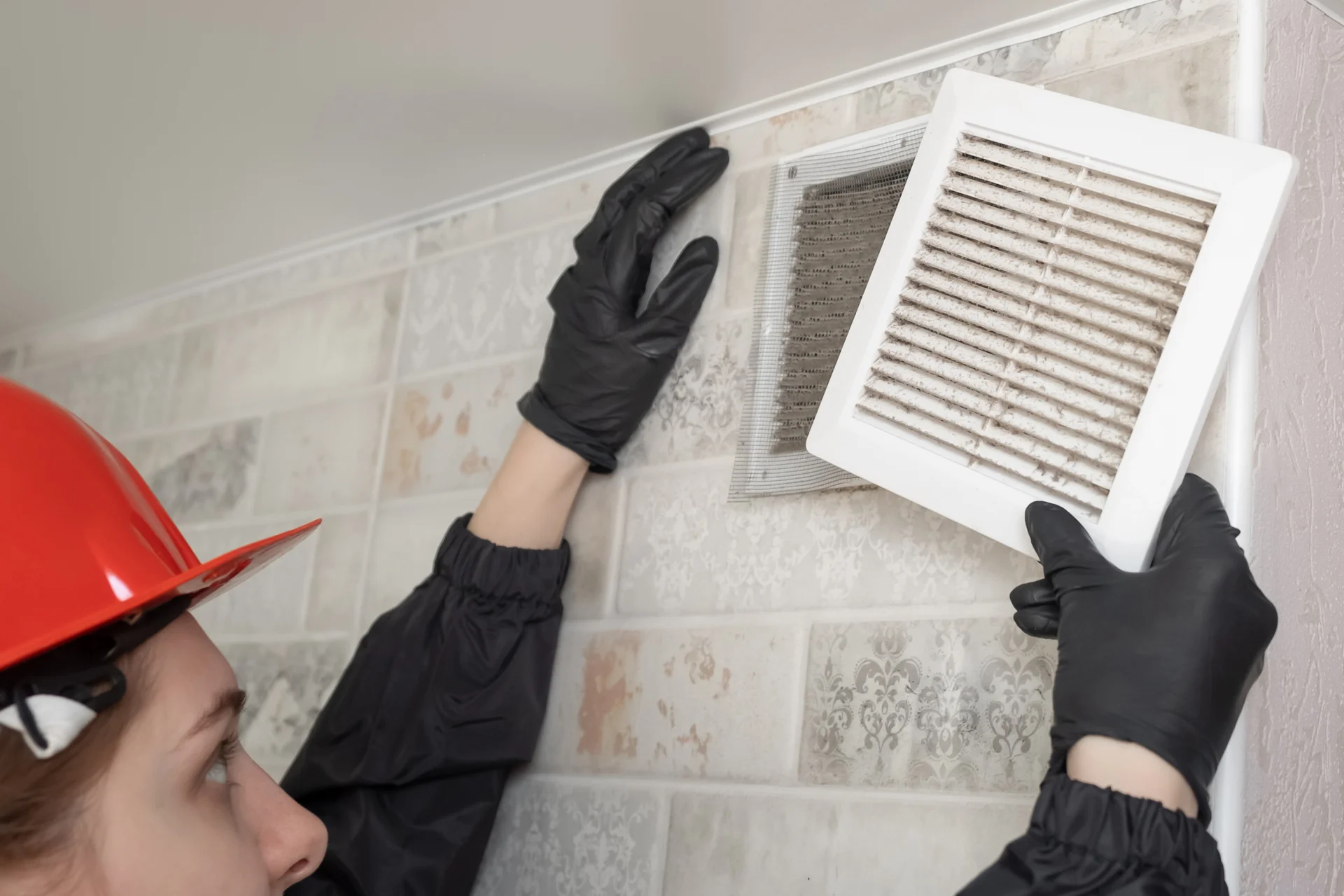 Female worker doing air vent cleaning